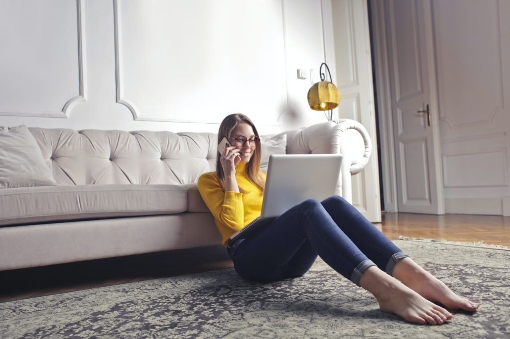 happy adult woman talking on phone and using laptop while 3768998